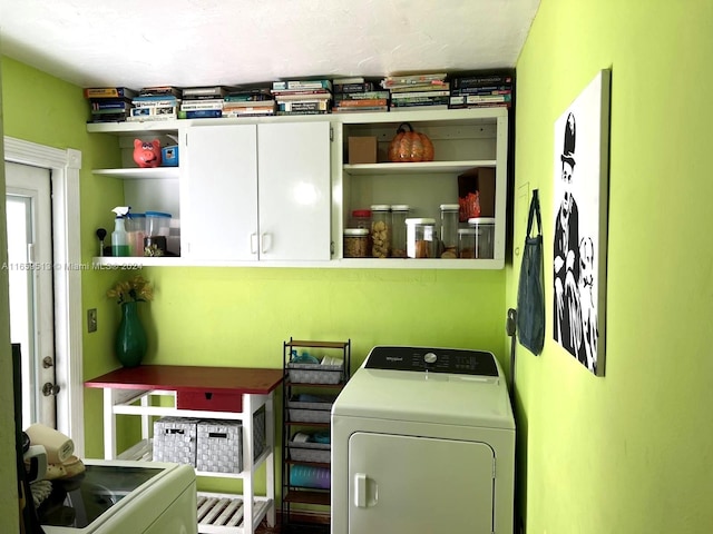 washroom with cabinets and washing machine and dryer