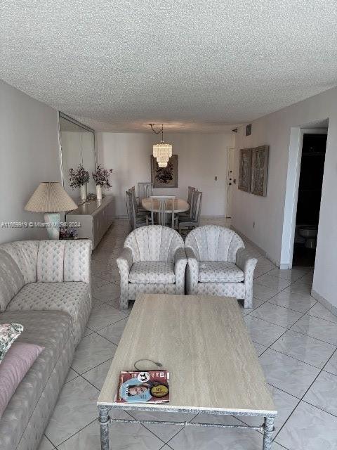 tiled living room featuring a textured ceiling