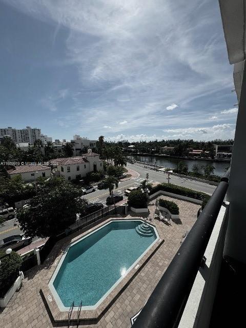 view of swimming pool featuring a water view and a patio