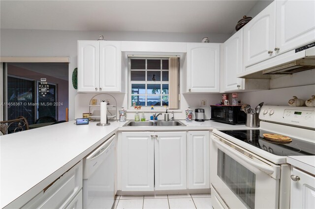 kitchen with white cabinets, light tile patterned floors, custom range hood, white appliances, and sink