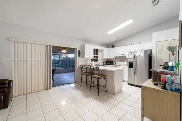 kitchen with white cabinetry, a kitchen bar, kitchen peninsula, stainless steel fridge with ice dispenser, and vaulted ceiling