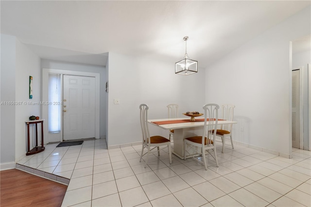 dining space with a notable chandelier and light hardwood / wood-style floors