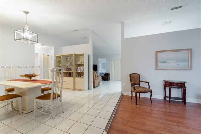 dining room featuring light wood-type flooring and lofted ceiling