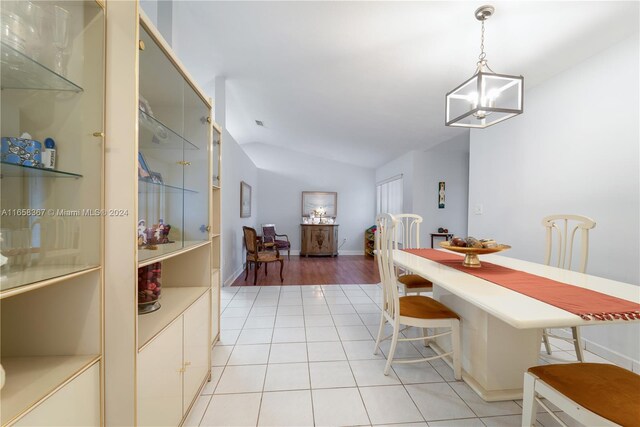 dining space featuring vaulted ceiling and light hardwood / wood-style floors