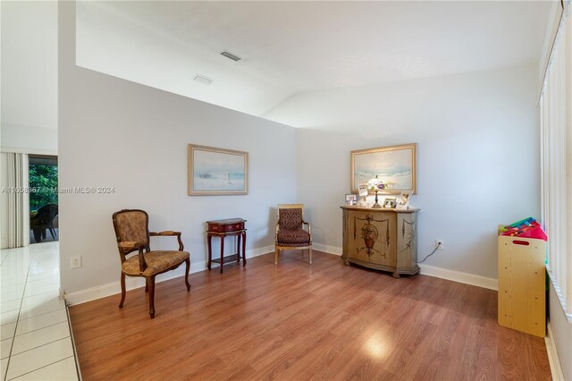 living area with lofted ceiling and light wood-type flooring