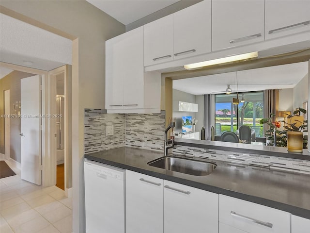 kitchen featuring decorative backsplash, light tile patterned flooring, white dishwasher, white cabinets, and sink