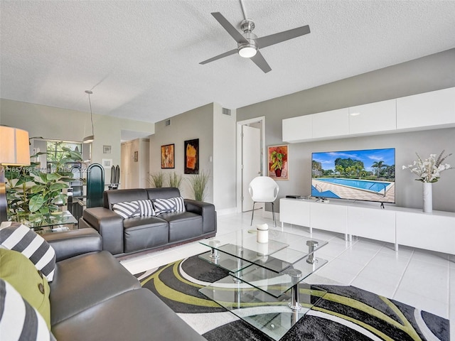 tiled living room with ceiling fan and a textured ceiling