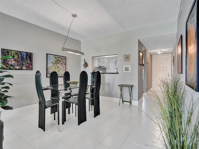 tiled dining space featuring a textured ceiling