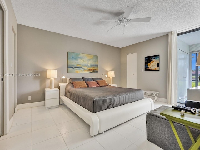 tiled bedroom featuring ceiling fan and a textured ceiling