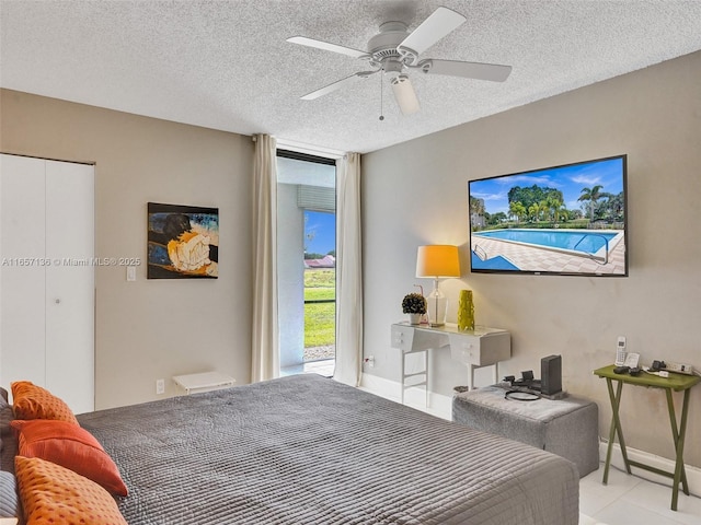 bedroom featuring a textured ceiling, ceiling fan, light tile patterned floors, and a closet