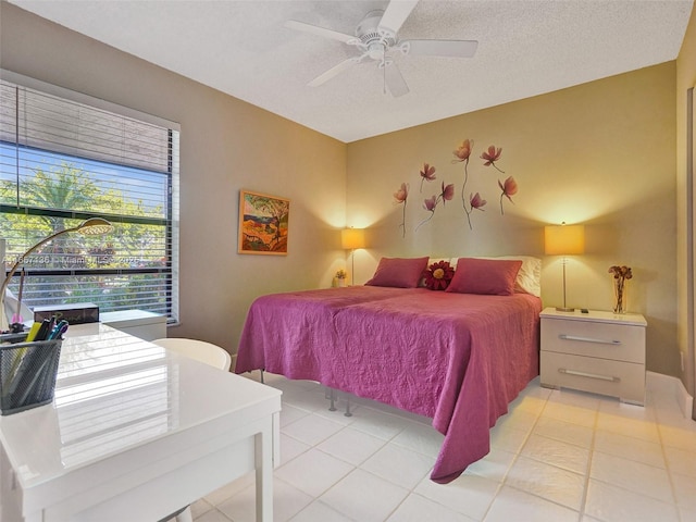 tiled bedroom with a textured ceiling and ceiling fan