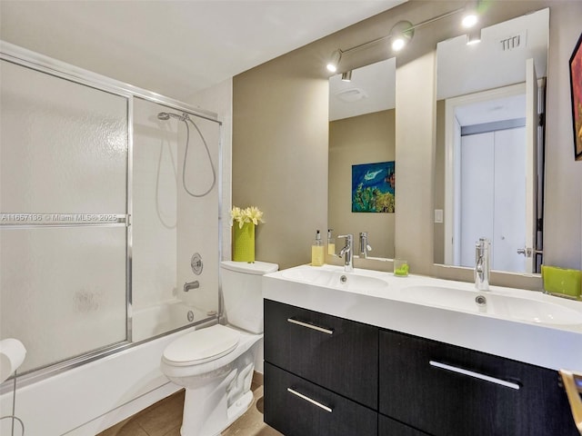 full bathroom featuring combined bath / shower with glass door, vanity, toilet, and tile patterned flooring