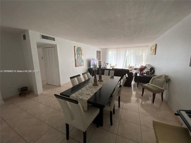 dining area featuring light tile patterned flooring and a textured ceiling