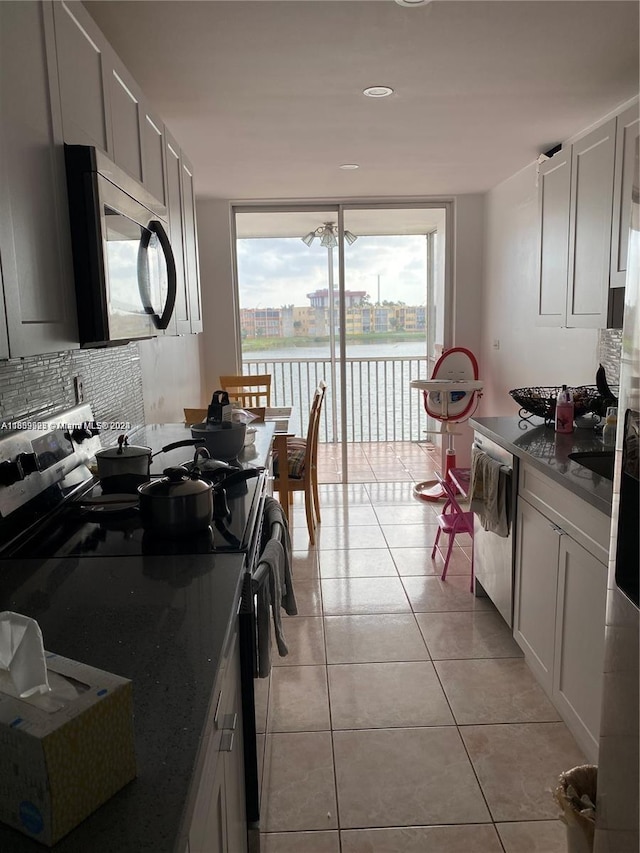 kitchen with plenty of natural light, stainless steel appliances, light tile patterned floors, and backsplash