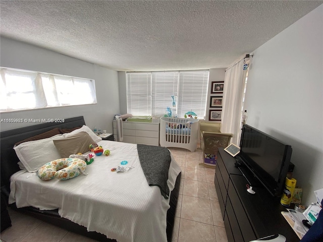 bedroom featuring light tile patterned floors and a textured ceiling