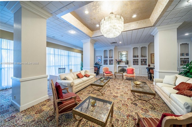 living room with carpet floors, a tray ceiling, ornamental molding, and a notable chandelier