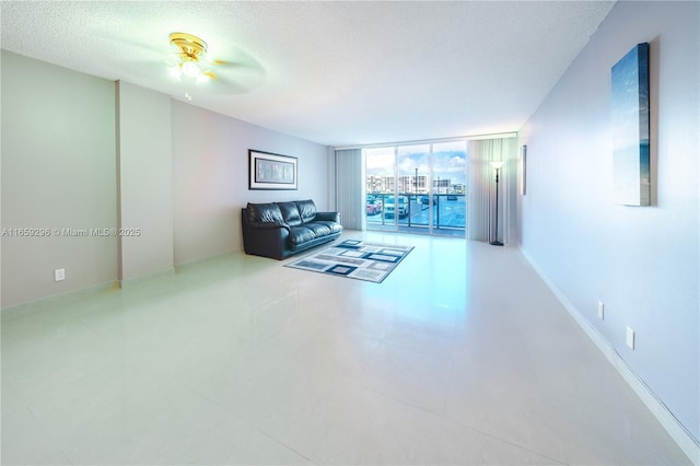 living room featuring floor to ceiling windows, ceiling fan, and a textured ceiling