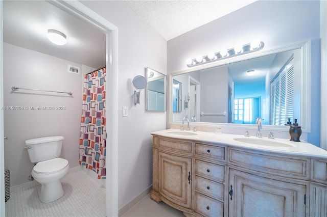 bathroom with curtained shower, tile patterned flooring, a textured ceiling, toilet, and vanity