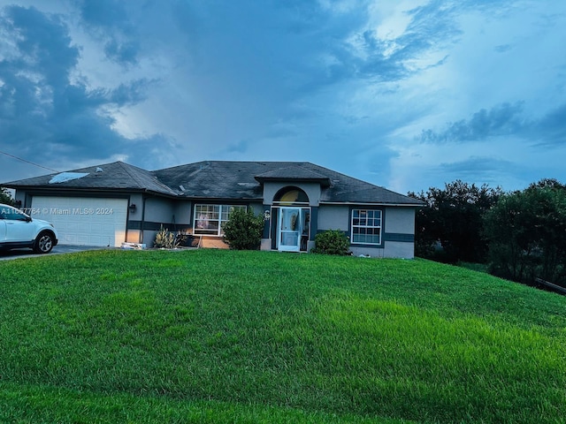 ranch-style house featuring a front yard and a garage