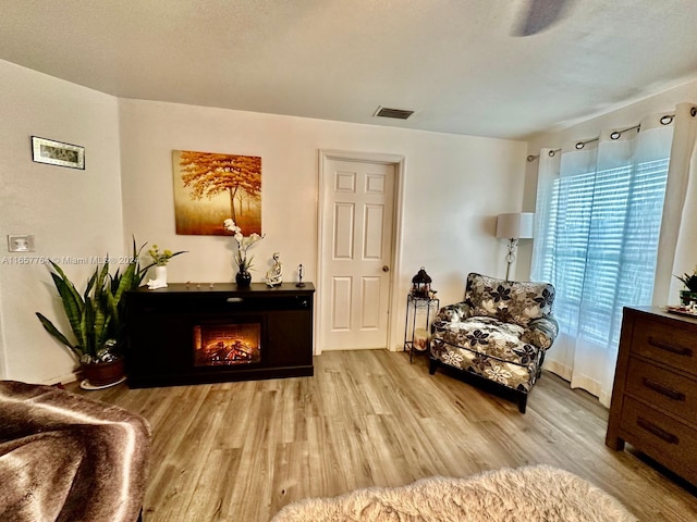 living area featuring a textured ceiling and light wood-type flooring