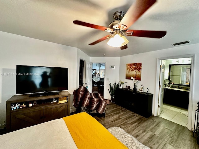 bedroom featuring ceiling fan, hardwood / wood-style flooring, and ensuite bath