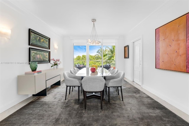 dining space with ornamental molding, a chandelier, and dark colored carpet