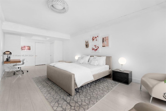 bedroom featuring crown molding and light hardwood / wood-style flooring