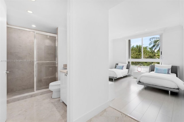 bathroom featuring a shower with door, toilet, and vanity