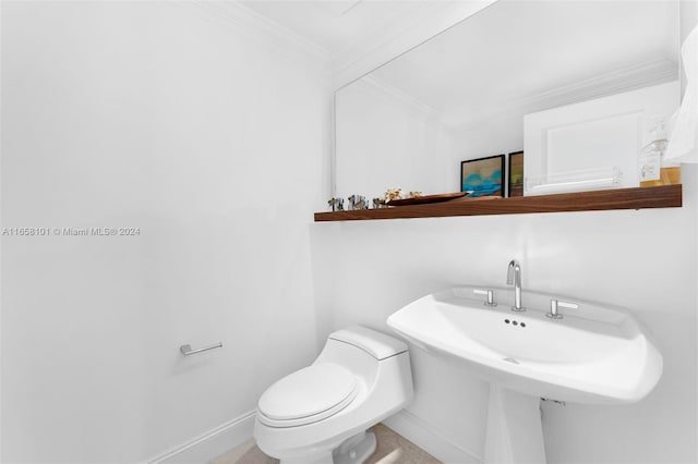 bathroom with toilet, ornamental molding, and sink