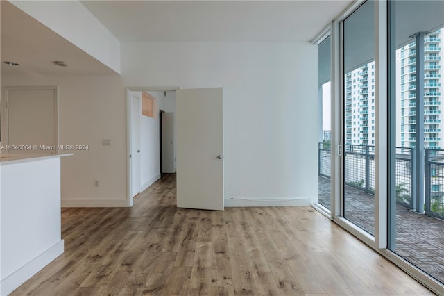 empty room with light hardwood / wood-style flooring, plenty of natural light, and expansive windows