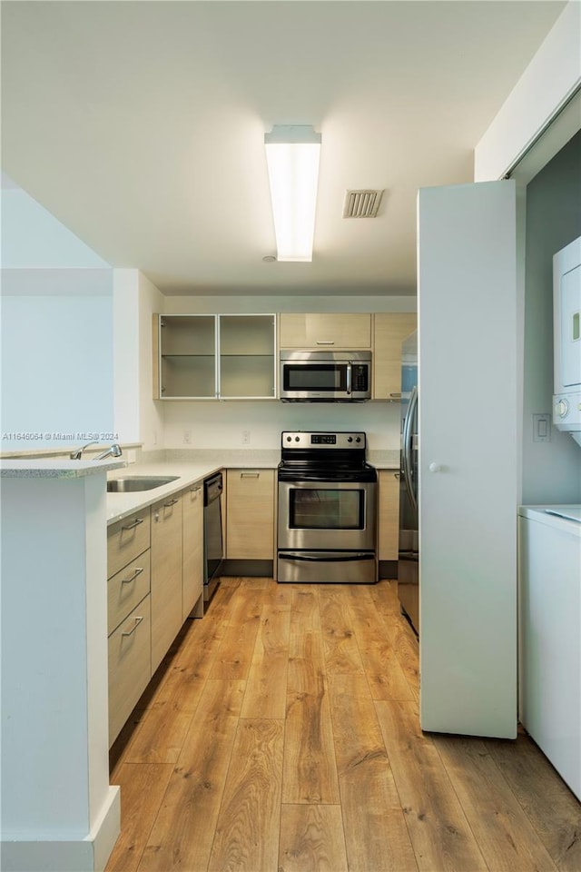 kitchen featuring light brown cabinets, light hardwood / wood-style flooring, stainless steel appliances, and sink