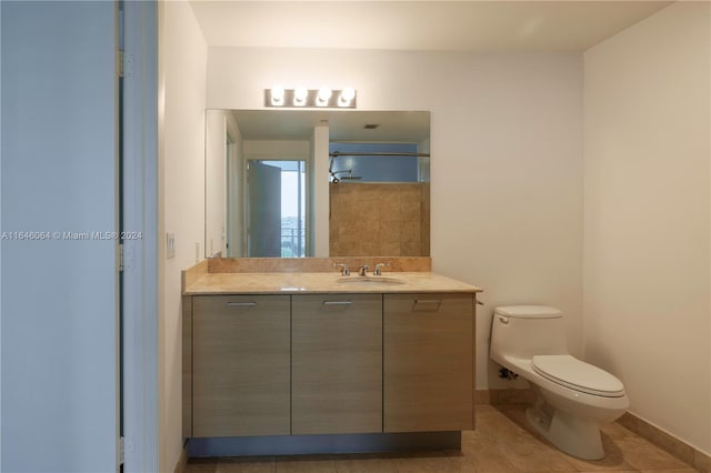 bathroom featuring tile patterned flooring, vanity, and toilet