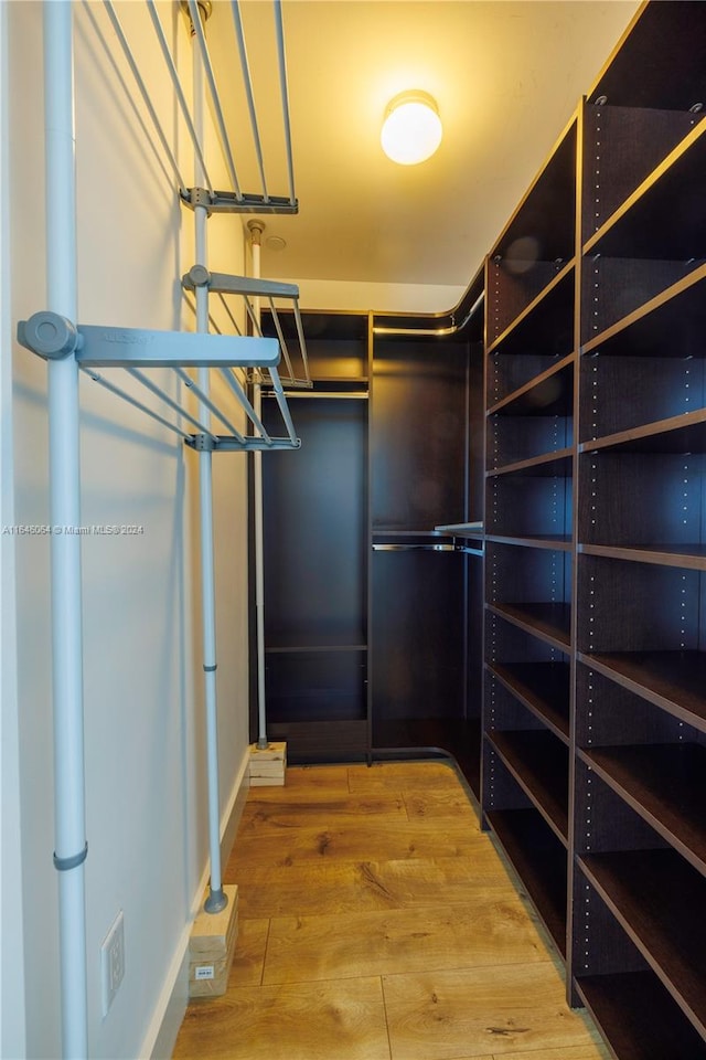 walk in closet with hardwood / wood-style floors