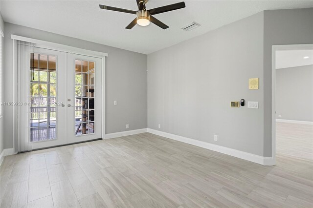 spare room featuring light hardwood / wood-style floors, ceiling fan, and french doors