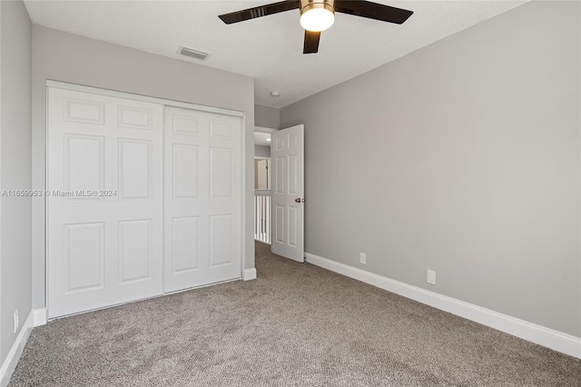 unfurnished bedroom with ceiling fan, a closet, and carpet