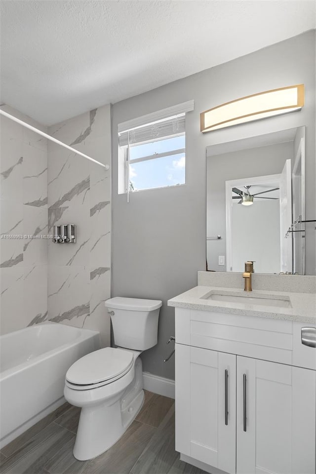 full bathroom featuring a textured ceiling, tiled shower / bath combo, hardwood / wood-style floors, vanity, and toilet