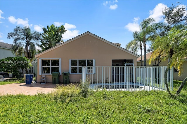 rear view of house featuring a lawn and a patio area