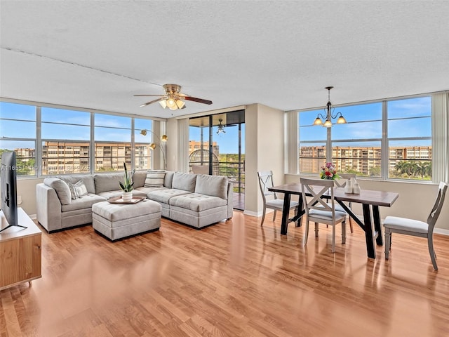 900 Saint Charles Pl Unit 718, Pembroke Pines, FL 33026 - living room with wood finished floors, a textured ceiling, a chandelier, healthy amount of natural light, and ceiling fan
