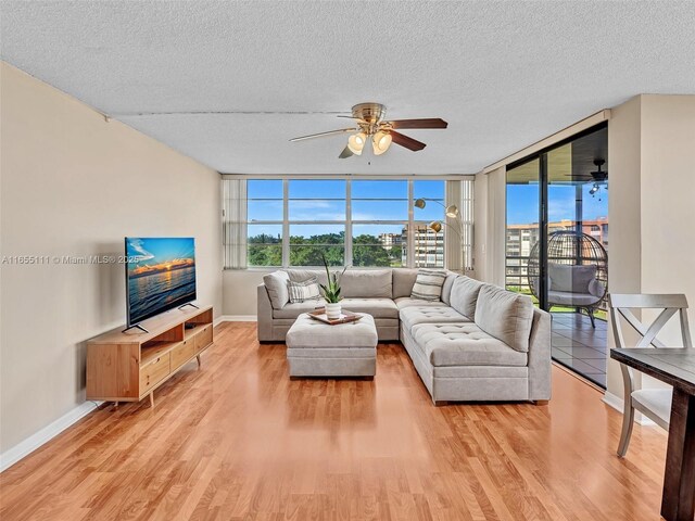 900 Saint Charles Pl Unit 718, Pembroke Pines, FL 33026 - living area with ceiling fan, healthy amount of natural light, a textured ceiling, light wood-type flooring, and a wall of windows