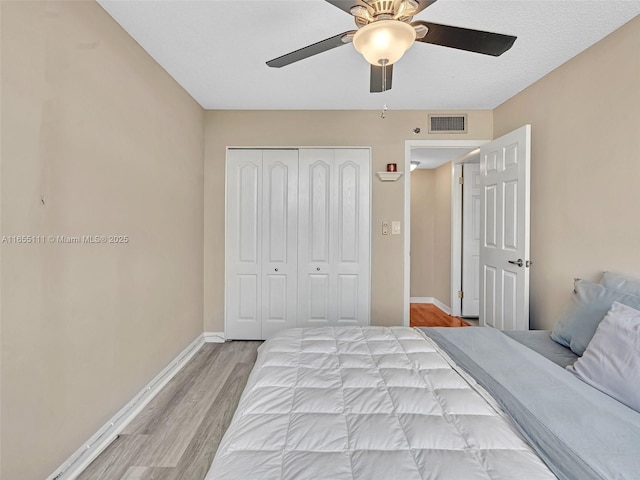 bedroom featuring ceiling fan, a closet, and light wood-type flooring