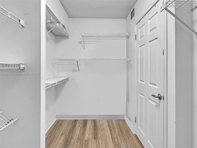 spacious closet featuring hardwood / wood-style floors