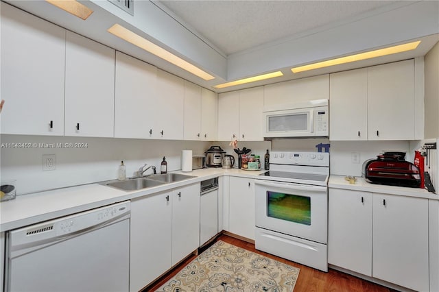 kitchen featuring white appliances, sink, a textured ceiling, light hardwood / wood-style floors, and white cabinets