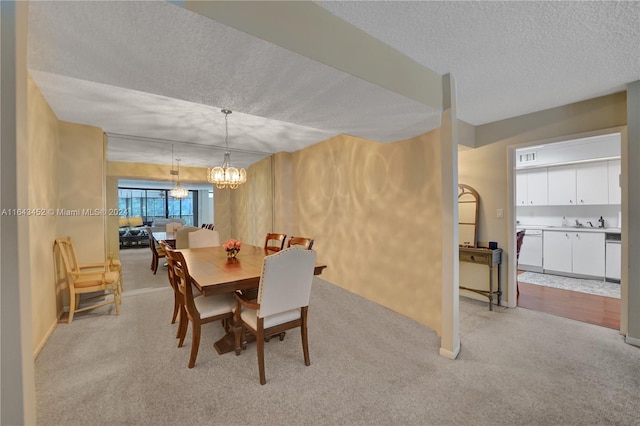 carpeted dining room with an inviting chandelier and a textured ceiling