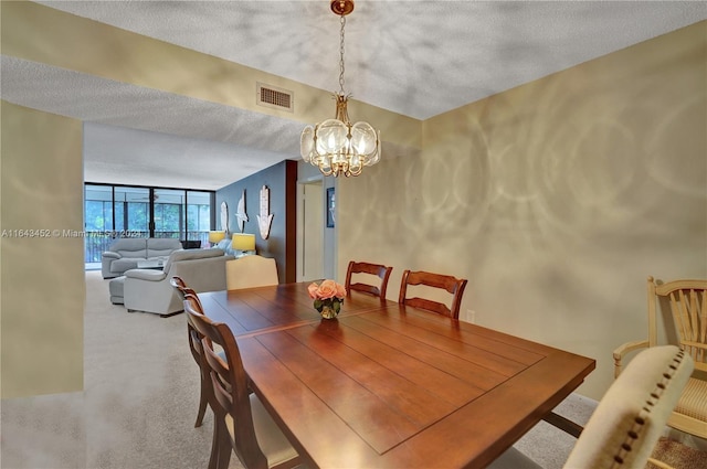 carpeted dining area with a textured ceiling and an inviting chandelier