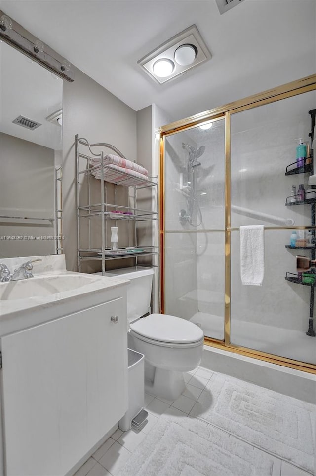 bathroom featuring vanity, toilet, tile patterned floors, and a shower with door