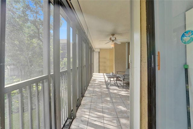 unfurnished sunroom with ceiling fan