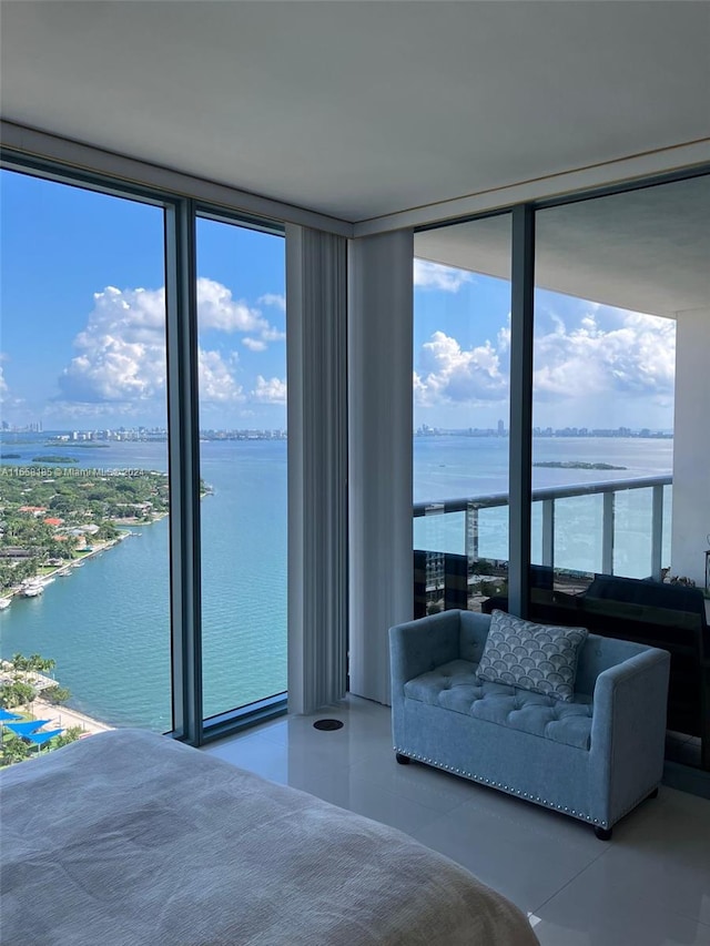 unfurnished bedroom featuring a wall of windows and a water view