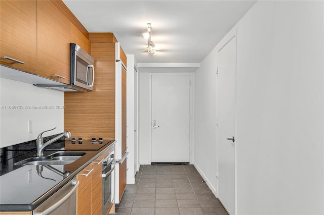 kitchen featuring stainless steel appliances, sink, and light tile patterned floors