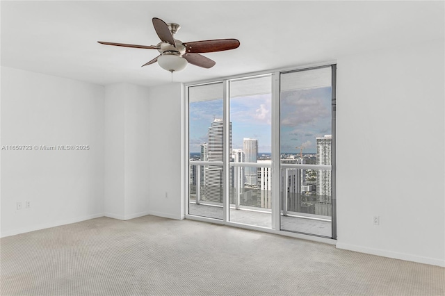 carpeted empty room with floor to ceiling windows and ceiling fan