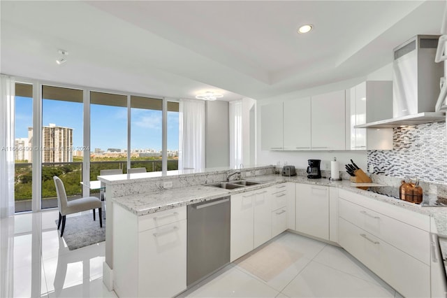 kitchen with stainless steel dishwasher, kitchen peninsula, backsplash, and white cabinets